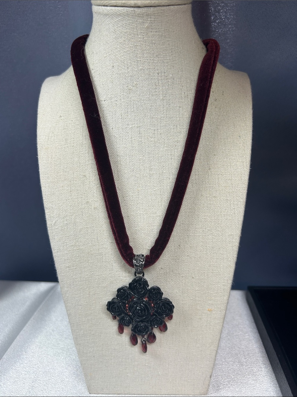 Gothic-style necklace featuring a black rose pendant with red dangles